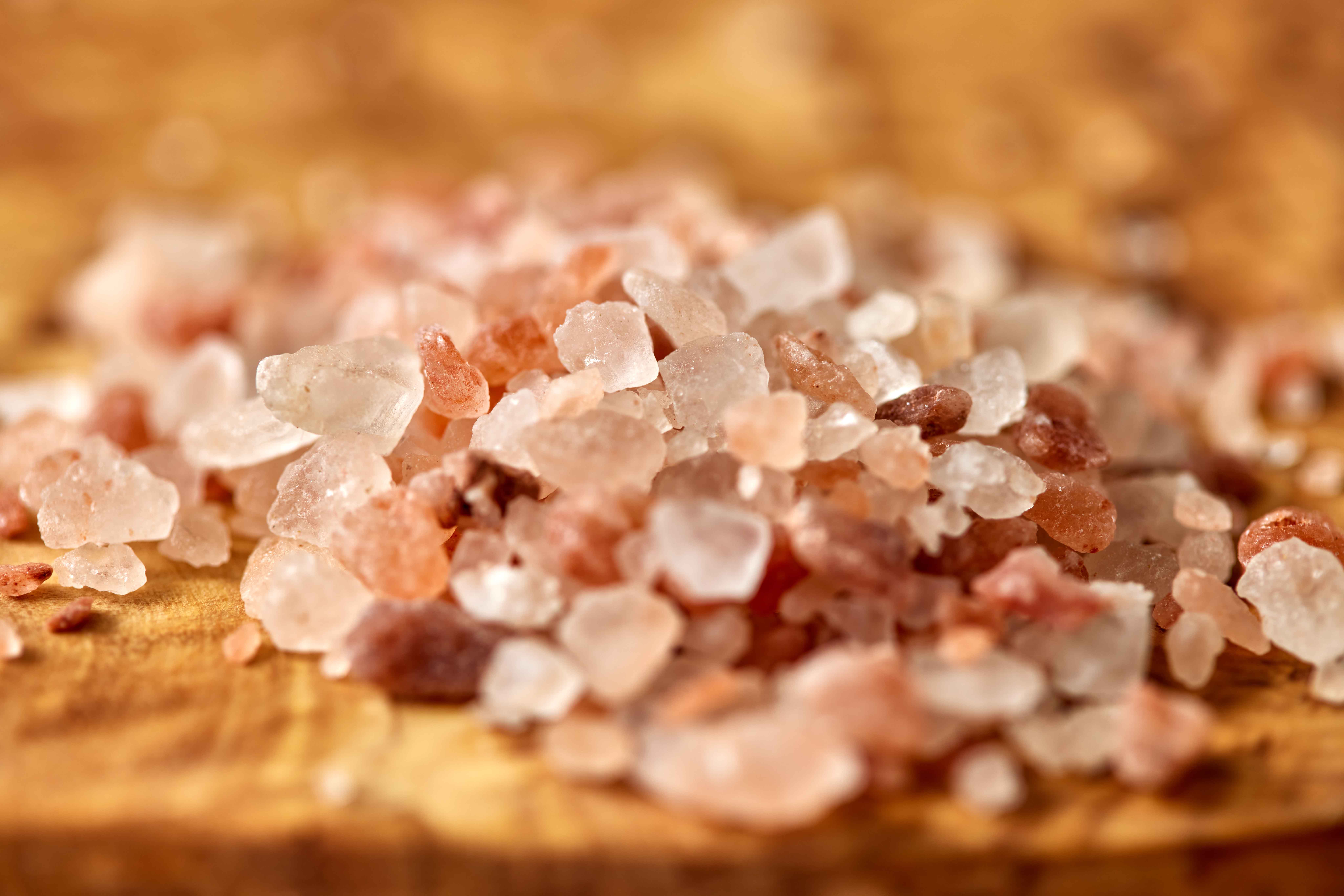 Himalayan pink salt crystals on wooden board